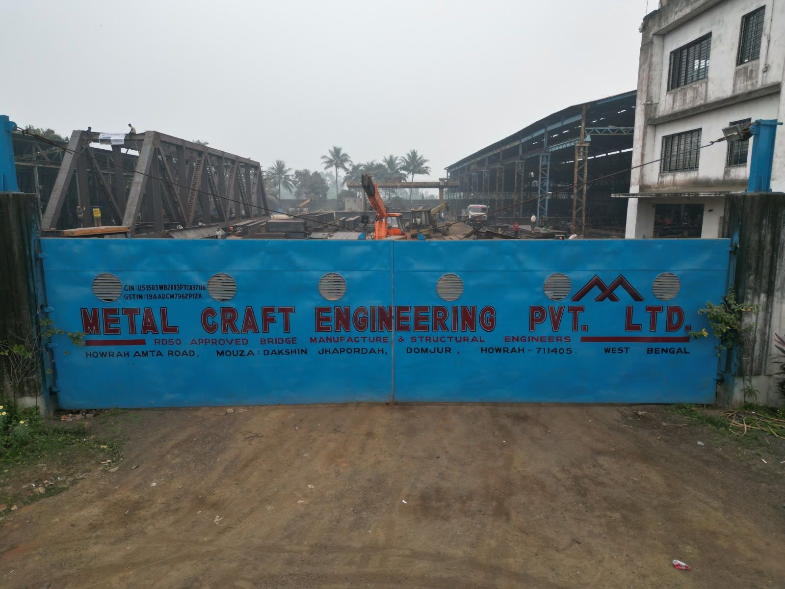 Blue entrance gate of the Metal Craft Engineering works in Kolkata, with the company name in red