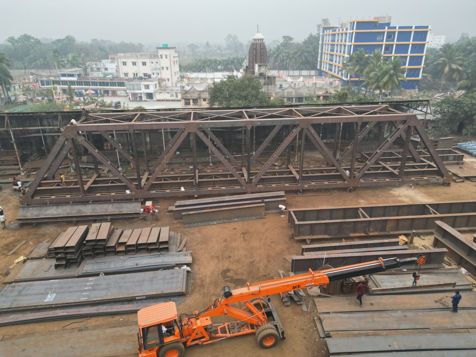 Steel truss girder being assembled in the Metal Craft yard in Kolkata, with a mobile crane and plate stock